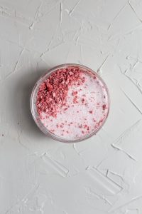 Freeze dried strawberries mixed with sugar in a small glass bowl