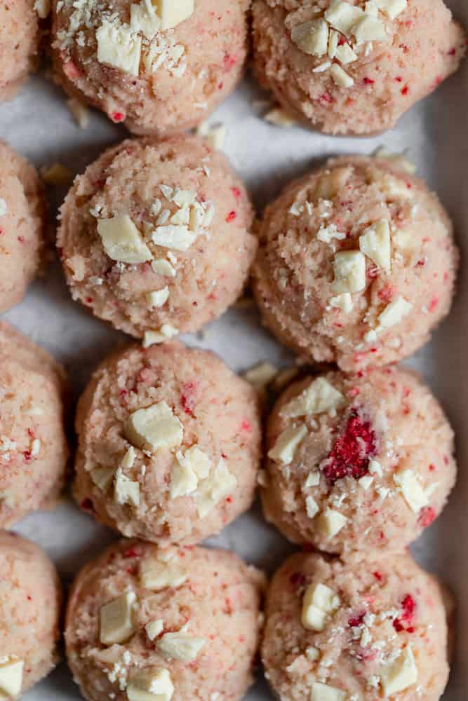 Strawberry cookie dough balls on a cookie sheet