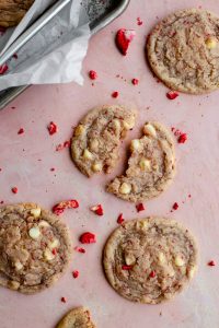 strawberry cookies broken apart on a pink surface