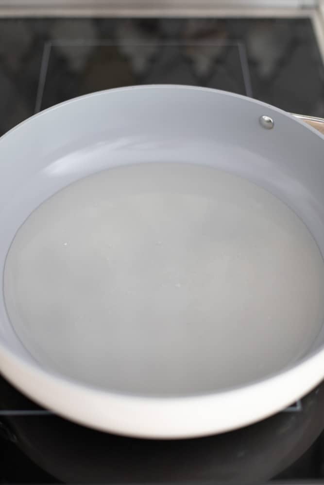 Water and sugar in a light gray bottomed pot