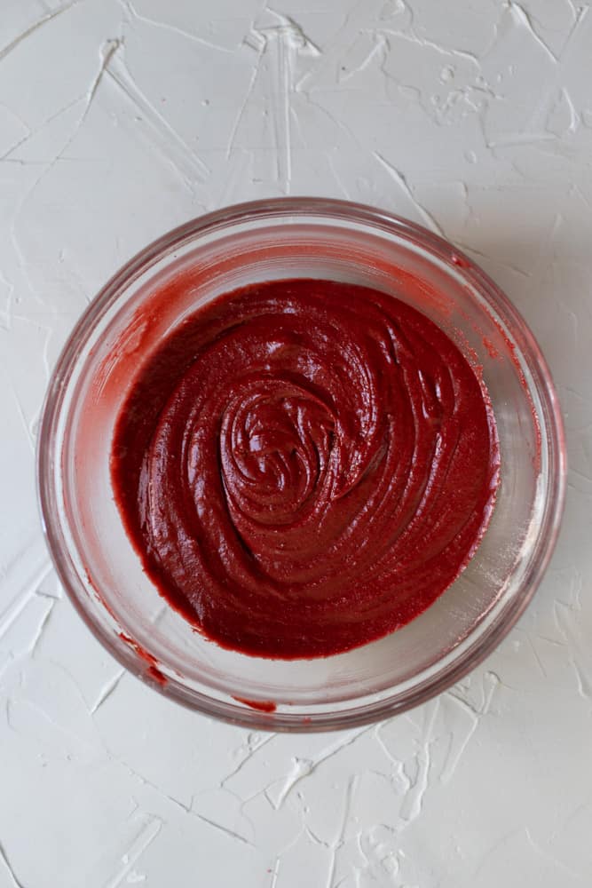 red velvet brownie batter in a glass bowl on a light gray surface