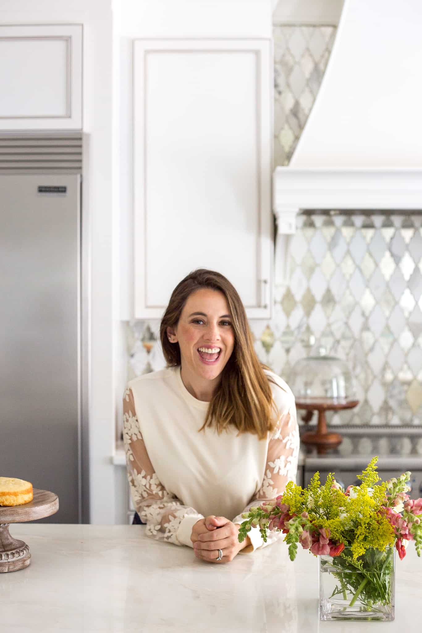 a woman standing in her white kitchen