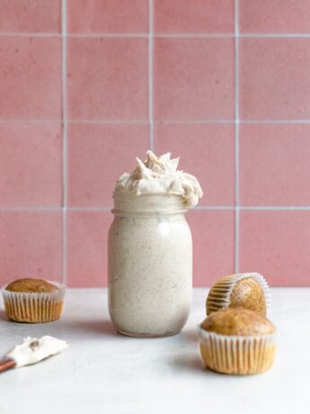Espresso buttercream in a mason jar next to 3 unfrosted cupcakes