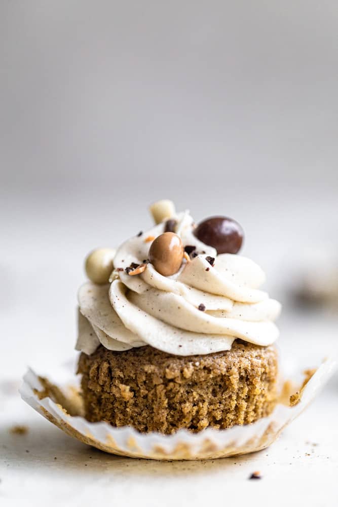 One espresso cupcake with it sliber pulled down on a gray surface