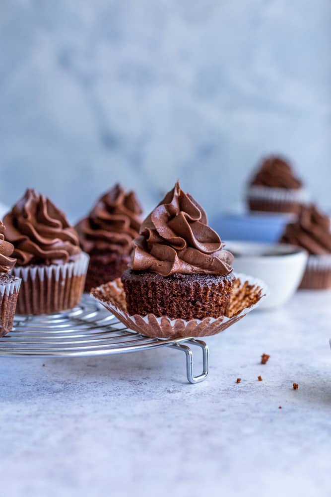 Chocolate filled cupcakes on a cooling rack with its wrapper undone