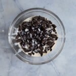 Chocolate and cream in a glass bowl on a blue surface