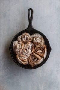 7 cinnamon rolls made out of phyllo rolled in a cast iron pan