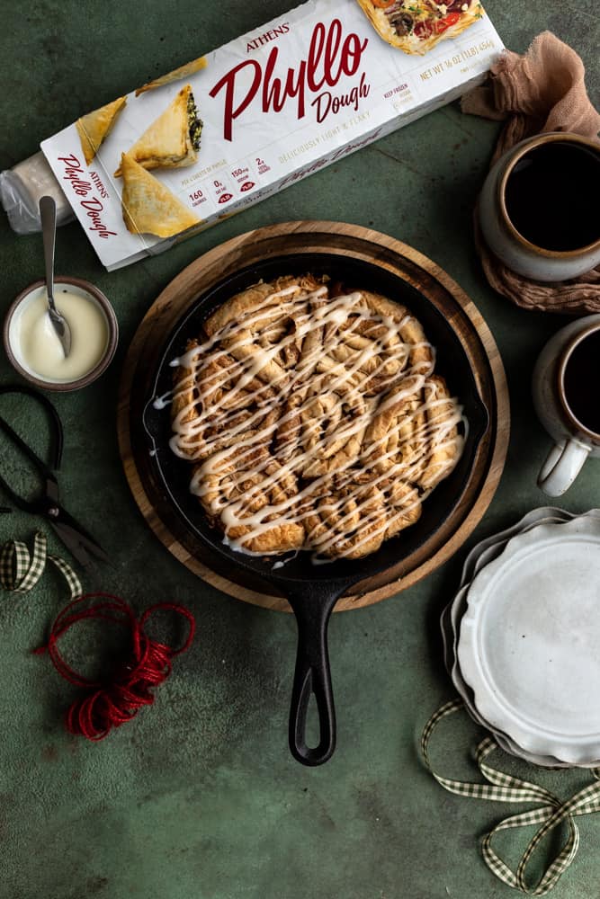 Cinnamon buns made out of phyllo dough in a cast iron skillet on a green surface