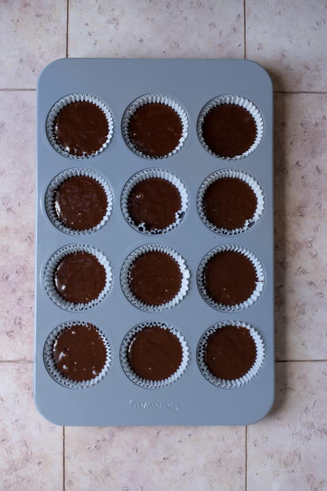 Chocolate cupcake batter in a muffin tin