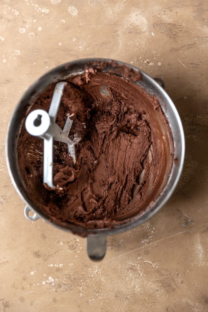 Chocolate and butter mixture in a stainless steel mixer bowl.