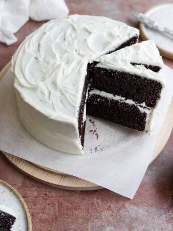 A chocolate cake with a few slices cut out and one on a diagonal next to the full cake.