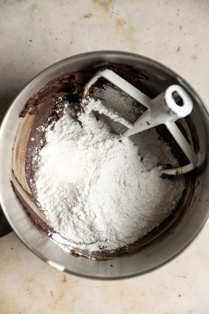 Powdered sugar added to creamed butter and cocoa powder.