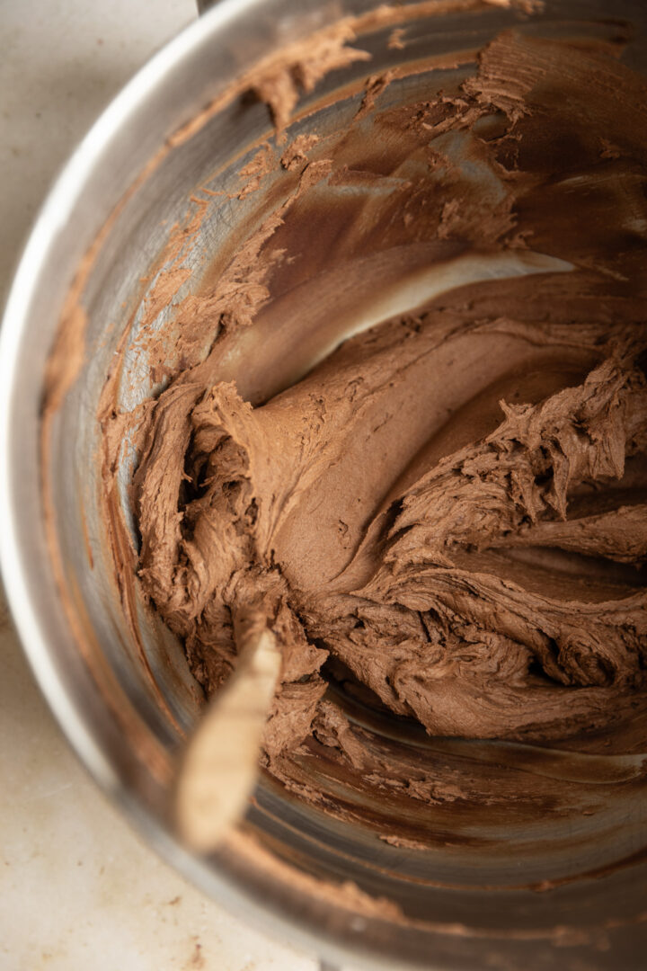 Chocolate buttercream frosting in a mixing bowl.