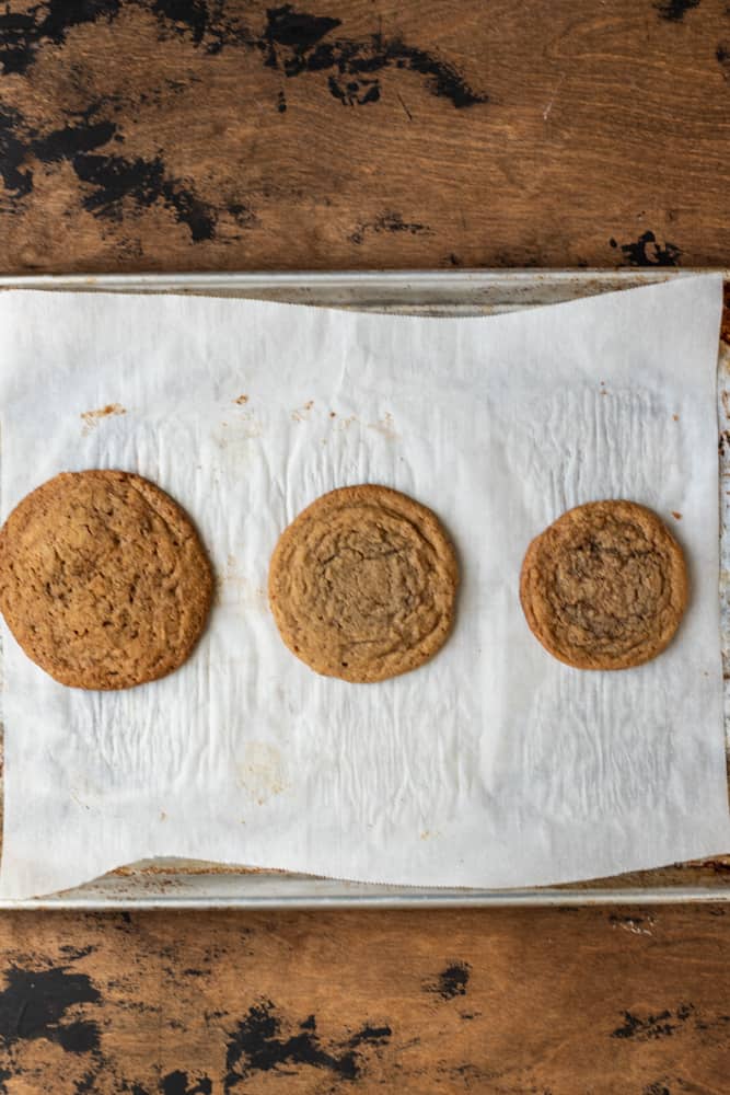 3 of the same cookies in 3 different sizes on a parchment lined cookie sheet.