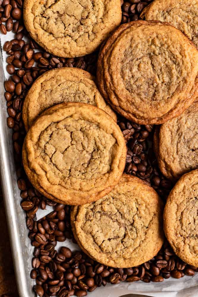 A bunch of coffee cookies on top of coffee beans.