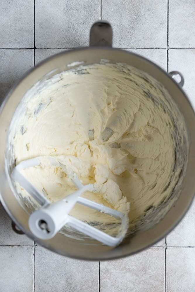 Creamed cheese, butter, and sugar mixed in a mixer bowl.