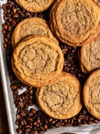 A bunch of coffee cookies on top of coffee beans.