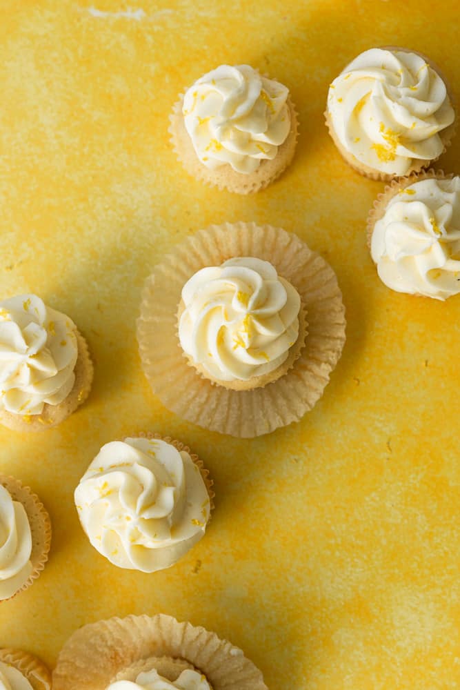 Lemon cupcakes on a yellow backdrop.
