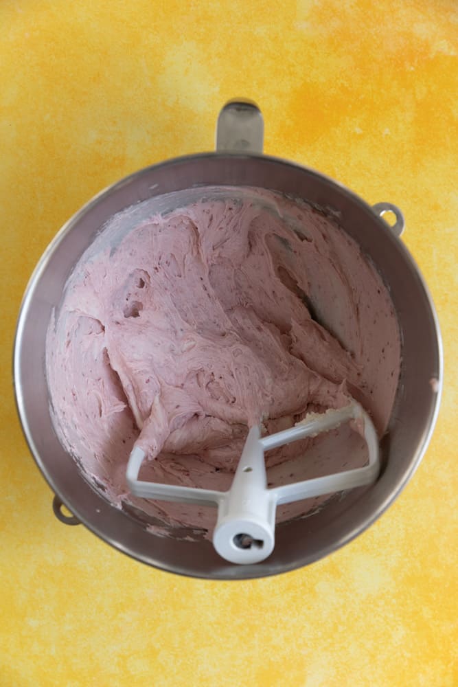 Strawberry buttercream made with strawberry jam in a mixing bowl.