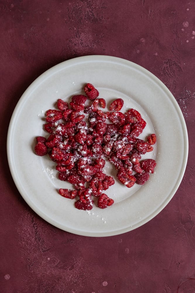 Fresh raspberries tossed with flour on a plate.