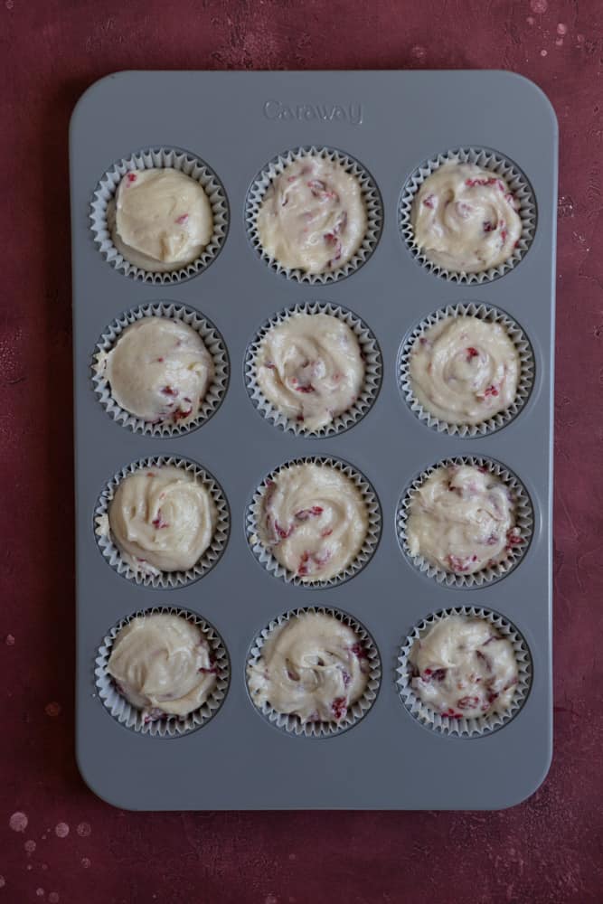 White chocolate raspberry cupcake batter in a muffin tin.