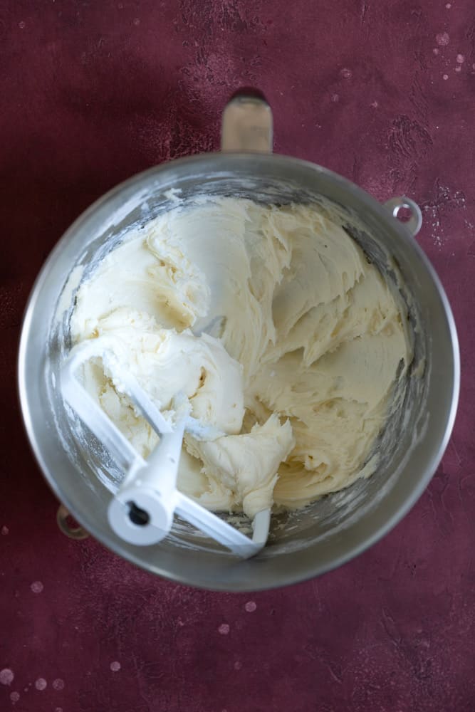 White chocolate buttercream frosting in a stainless steel mixing bowl.