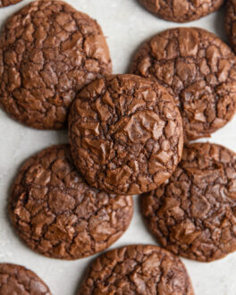 Brownie cookies stacked on top of each other on a gray surface.