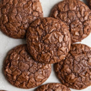 Brownie cookies stacked on top of each other on a gray surface.