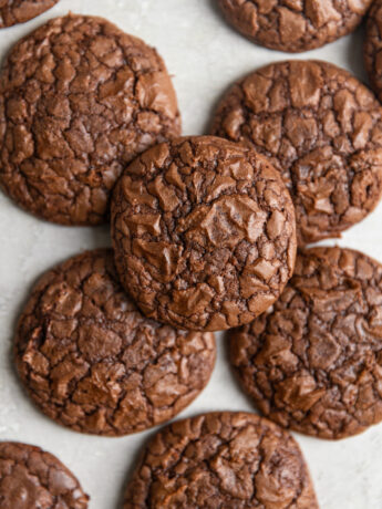 Brownie cookies stacked on top of each other on a gray surface.
