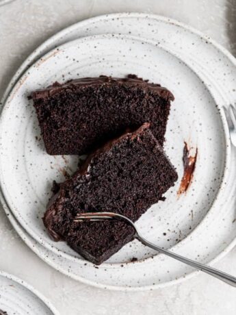 Two slices of chocolate loaf cake on a white plate.