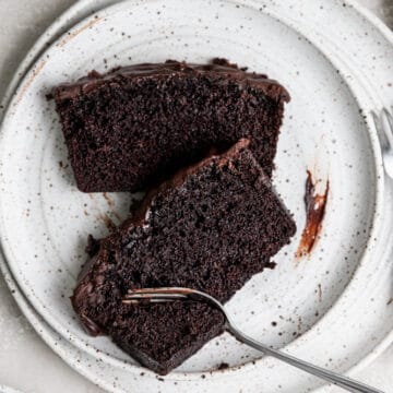 Two slices of chocolate loaf cake on a white plate.