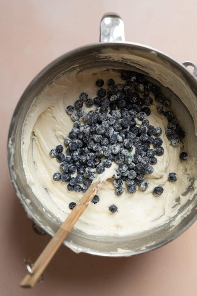 Blueberries added to batter in a mixing bowl.