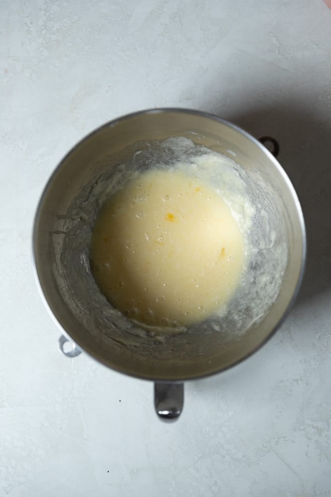 Butter, sugar, and eggs, mixed in a mixing bowl.
