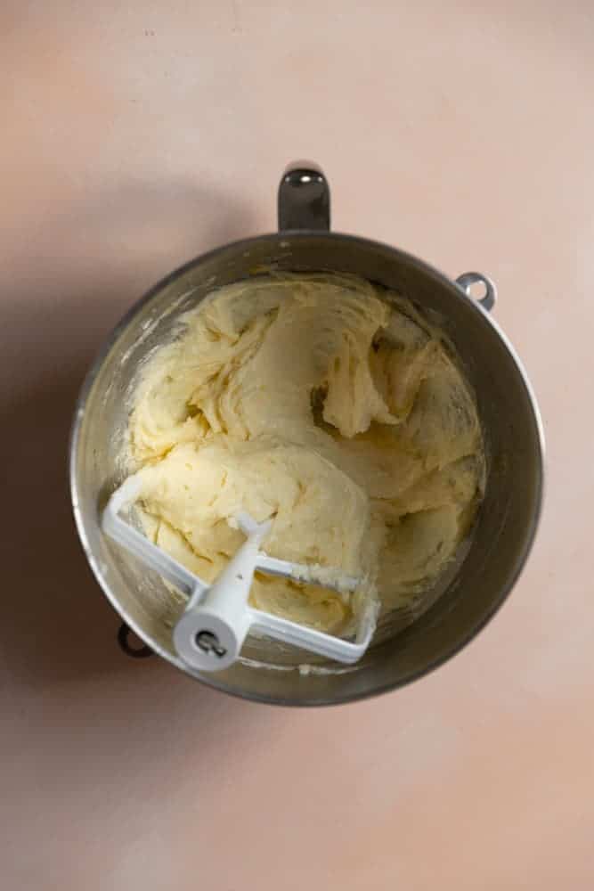 Butter, sugar, and eggs mixed together in a mixing bowl.