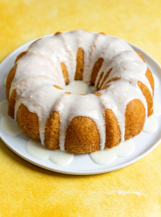 A bundt cake with a white lemon glaze drizzled on top.