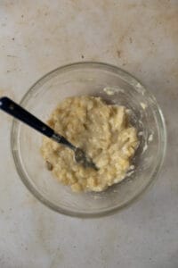 Mashed banana in a glass bowl.