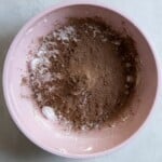 Cocoa powder and powdered sugar in a pink bowl.