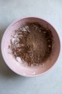 Cocoa powder and powdered sugar in a pink bowl.