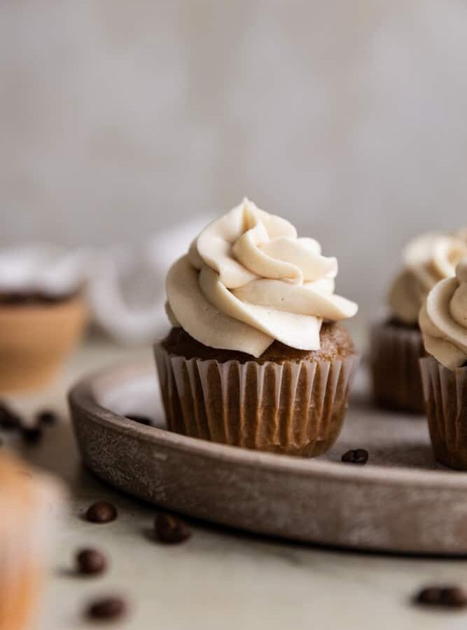 A coffee cupcake on a brown plate.