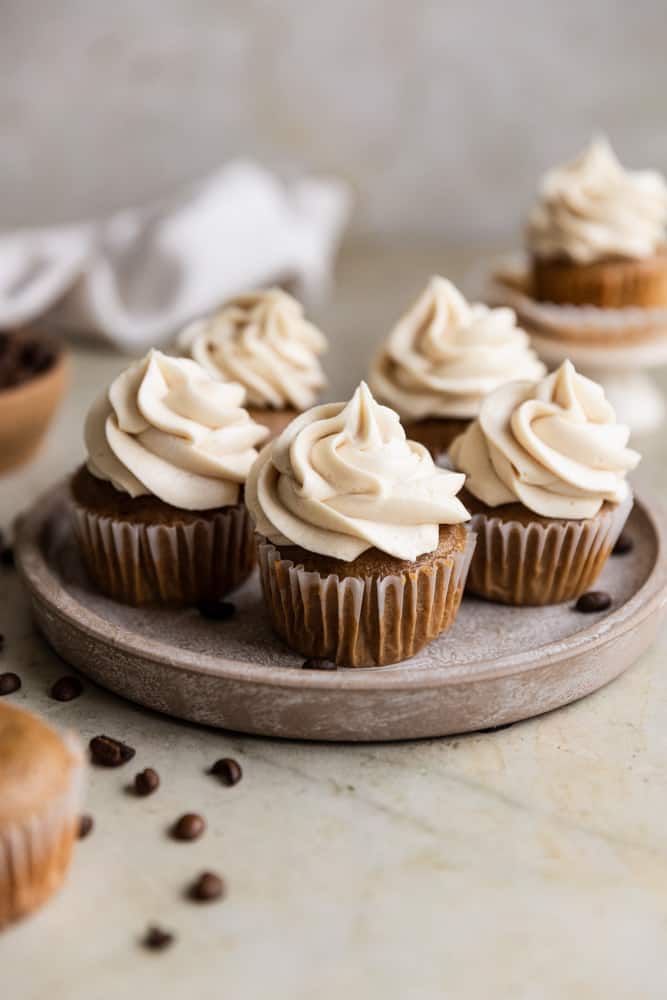 Coffee cupcakes on a plate on beige background.