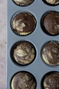 Baked marble cupcakes in a muffin tin.