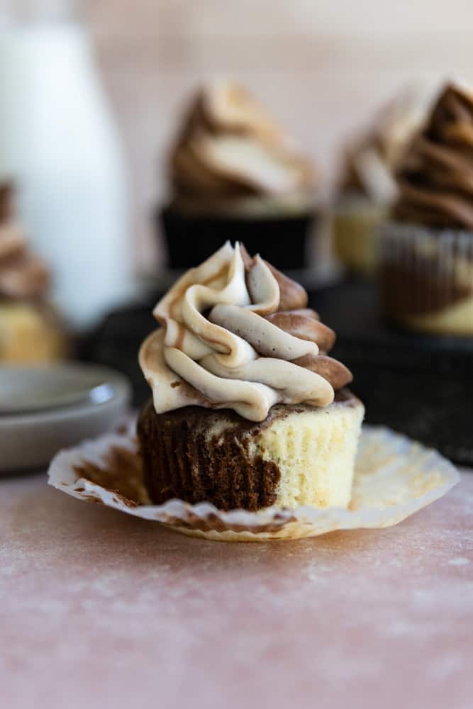 A marble cupcake with it's liner peeled down. 
