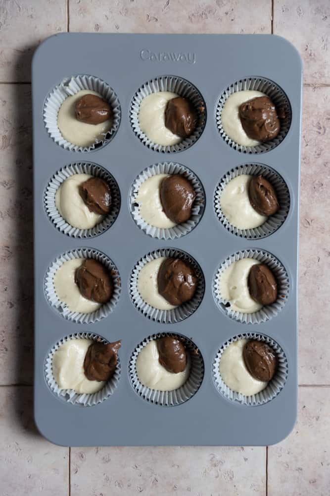 Vanilla and chocolate batter in a muffin tin.