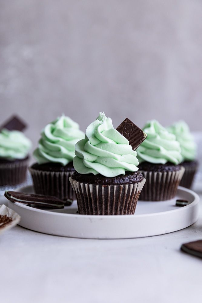 Mint chocolate cupcakes on a white plate.