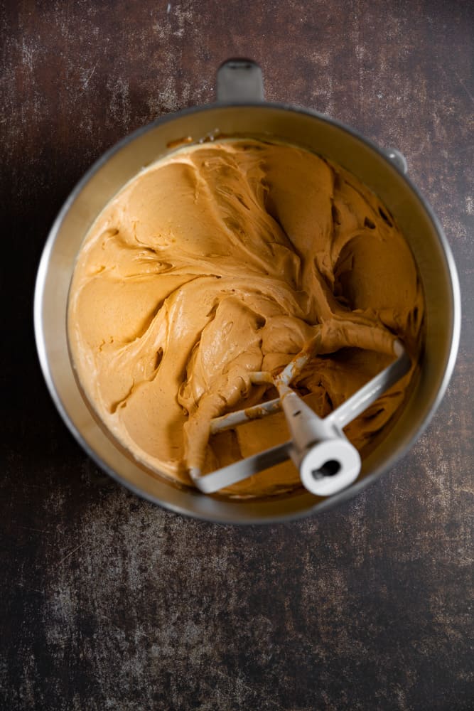 Pumpkin cream cheese frosting in a mixing bowl.