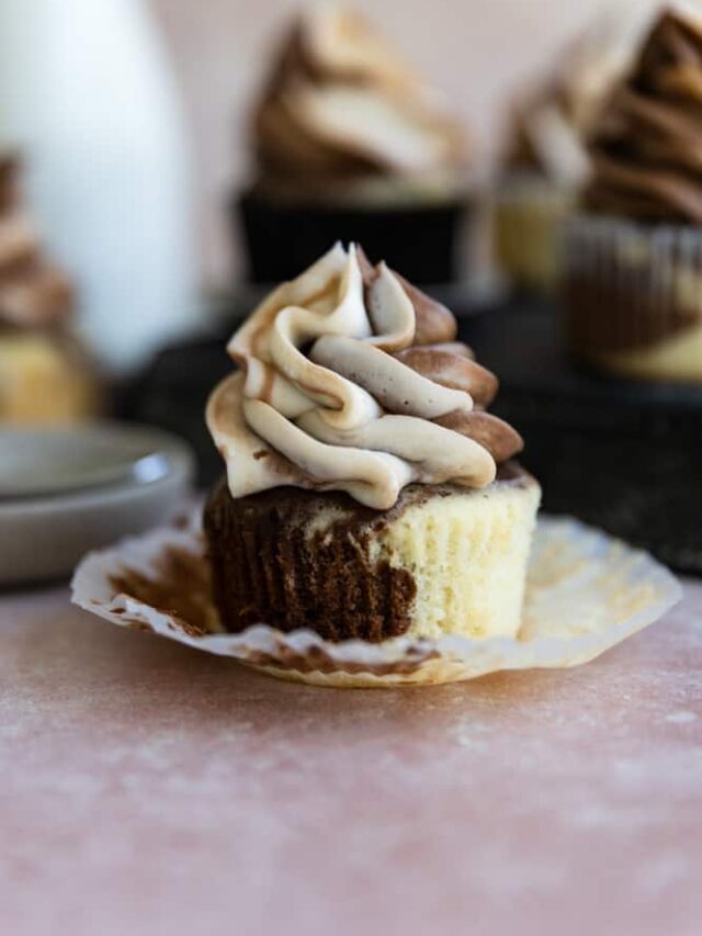 A marble cupcake with it's liner peeled down.