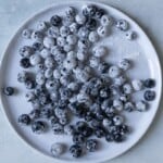 Blueberries dusted with flour on a white plate.