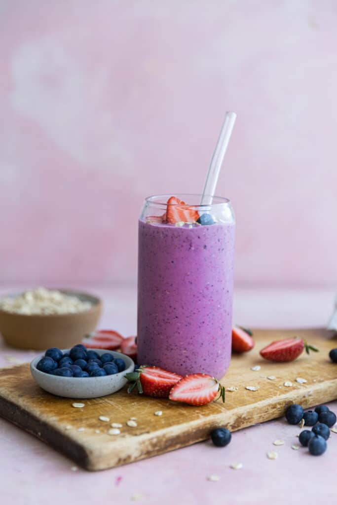 A purple smoothie on a wooden cutting board.