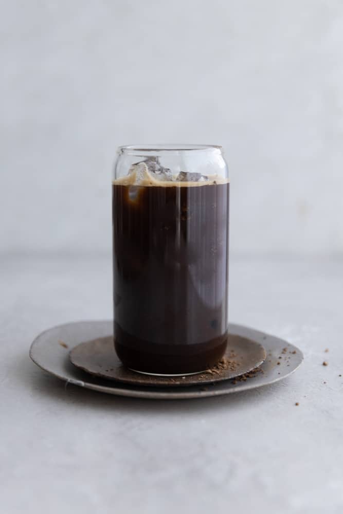 Black instant iced coffee with ice in a glass cup.