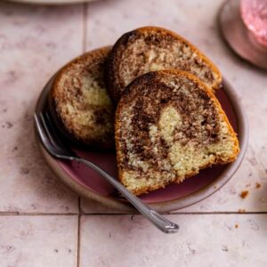 Three slices of marble bundt cake on a pink plate.